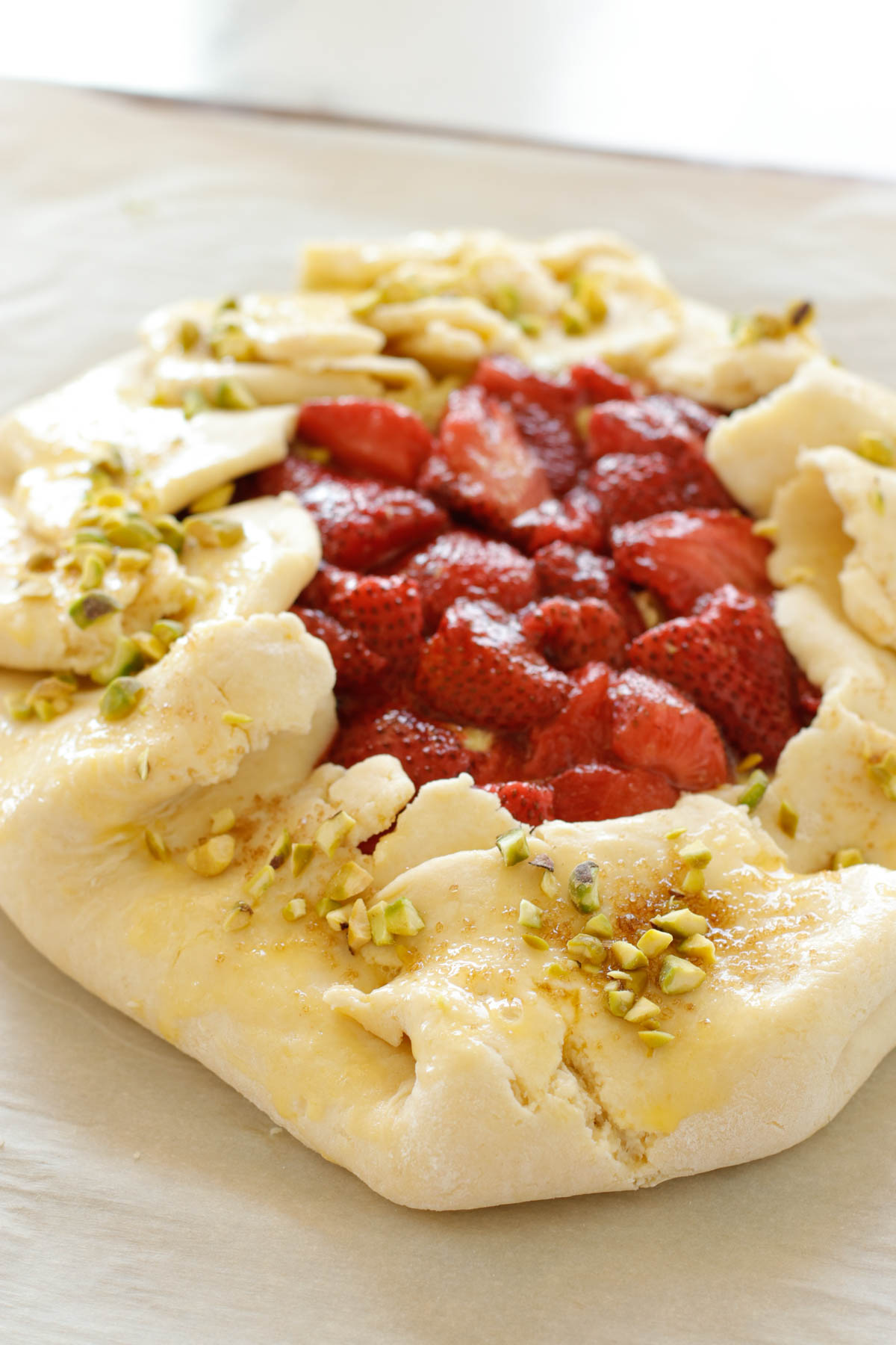 Strawberry Pistachio Tart - a double layer of strawberries with a pistachio frangipane make this tart sublime! Oh, let's not forget the sour cream crust. | circleofeaters.com